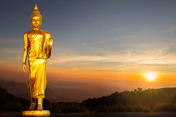 Golden Buddha statue on sunrise background