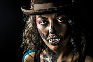 Beautiful woman with halloween make up posing isolated on black background. Close up, copy space.