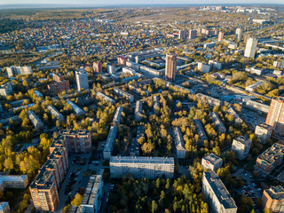 Wall Mural - Aerial view of landscape with a large number of residential buildings on the outskirts of the city on an autumn day during the Indian summer with the road and cars