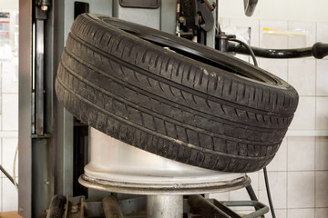 Canvas Print - Car wheel half taken from the disk to perform tire mounting and fitting on a special machine in the workshop for repairing vehicles before the start of the winter season