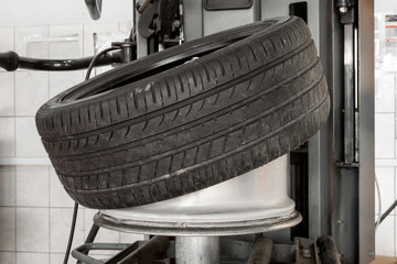 Canvas Print - Car wheel half taken from the disk to perform tire mounting and fitting on a special machine in the workshop for repairing vehicles before the start of the winter season