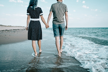 Canvas Print - Loving couple walking on sand coast.