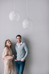 Young beautiful couple on a background of gray wall.