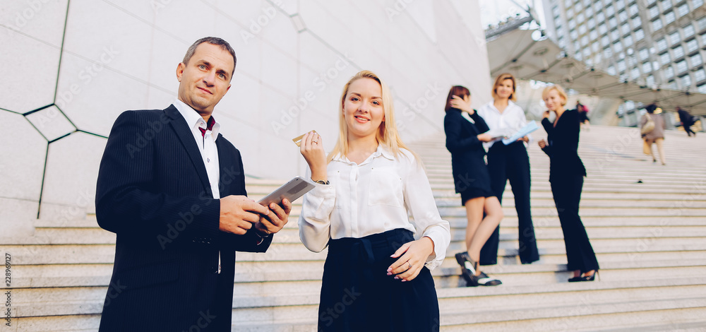 Boss keeping tablet and speaking with blonde secretary on stairs with ...