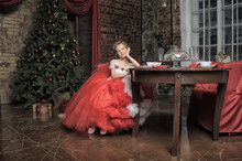Young Princess In A Red And White Dress Sitting
