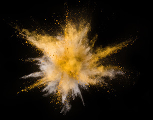Wall Mural - Explosion of yellow powder on black background