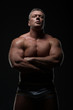 © Vladimir - Powerful muscular bodybuilder posing on a black background. concept of strength and health