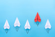 Red paper plane leading among a white planes on blue background. Business competition and Leadership concept