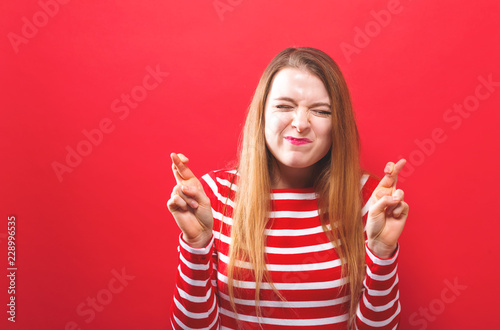 Fotografía Young woman crossing her fingers and wishing for good luck