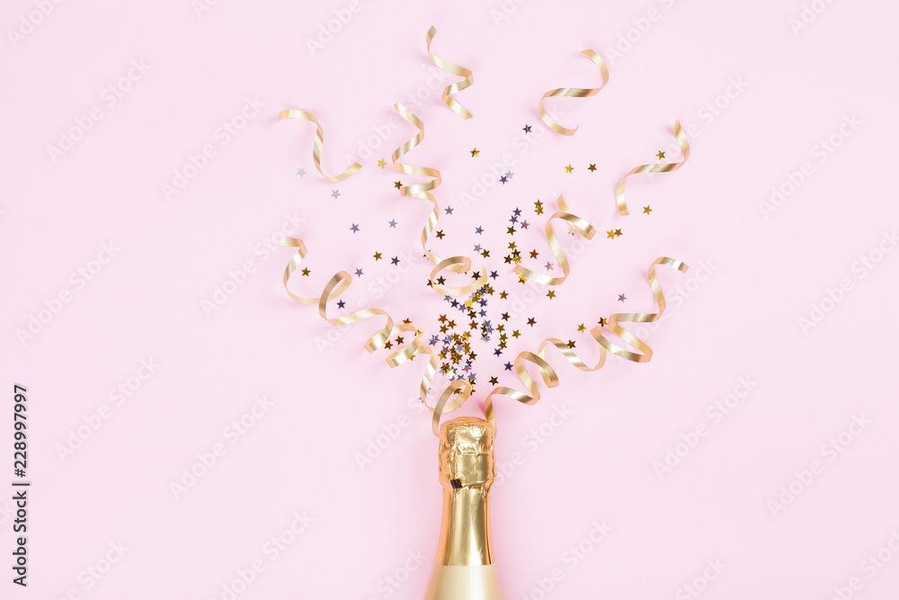 Champagne bottle with confetti stars and party streamers on pink background. Christmas, birthday or wedding concept. Flat lay style. - obrazy, fototapety, plakaty 