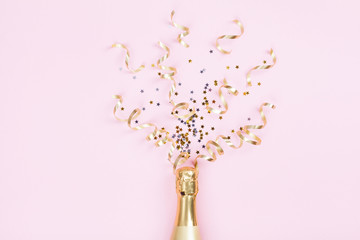 Wall Mural - Champagne bottle with confetti stars and party streamers on pink background. Christmas, birthday or wedding concept. Flat lay style.