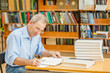 © Ermolaev Alexandr - Senior man is preparing for the exam in the library