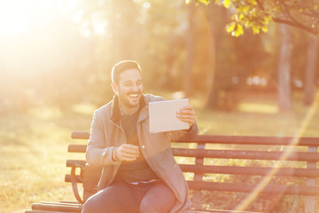 Wall Mural - Modern businessman using tablet in a park