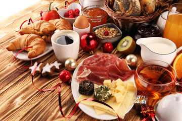 breakfast on table with bread buns, croissants, coffe and juice on christmas day. xmas holiday morning.