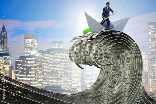 Cuadros en Lienzo Businessman riding paper boat in dollar sea