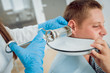 Medical ear washing with water in big syringe