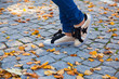 close-up of feet in jeans and sneakers on autumn Golden foliage