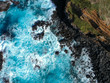© nvphoto - Aerial top view of sea waves hitting black volcanic rocks on the coastline with turquoise sea water. Amazing rock cliff seascape in the Portuguese coastline. Azores islands. Drone shot.