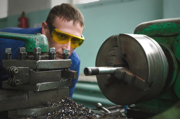 Wall Mural - Turner worker is working on a lathe machine in a factory.