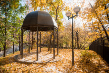 Gazebo, Lantern And Fence On The Background Of The Autumn Park