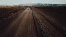 Epic Aerial Shot Of White SUV Driving Through Amazing Landscape In Iceland