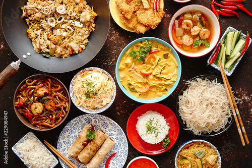 Asian oriental food composition in colorful dishware, served on dark rustic background, top view. Chinese, vietnamese, thai cuisine set. With copy space. © Dash