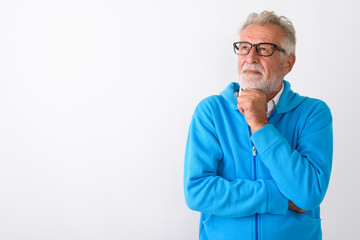 Wall Mural - Studio shot of handsome senior bearded man thinking while lookin