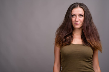 Portrait of young beautiful woman against gray background