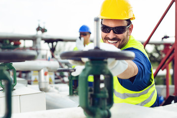 Wall Mural - Oil worker closes the valve on the oil pipeline