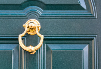 08 09 2018 Atri, Italy - golden door knocker on a traditional dark door