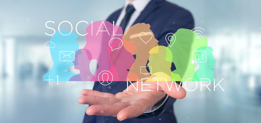 Poster - Businessman holding a colorfull social network teamwork with icon 3d rendering