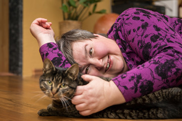 Poster - geistig behinderte Frau schmust mit einer Katze, tiergestütze Therapie