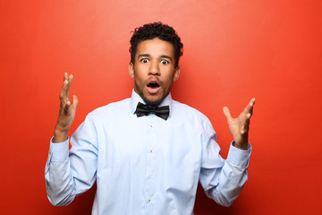 Wall Mural - Portrait of shocked African-American man on color background