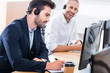 © LIGHTFIELD STUDIOS - selective focus of male call center operators in headsets with notebooks at workplace in office