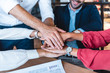© LIGHTFIELD STUDIOS - cropped shot fo business team holding hands at workplace in office