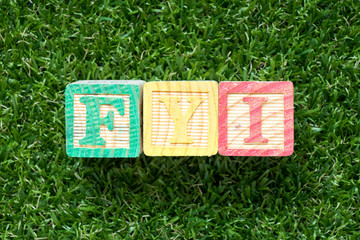 Sticker - Color wood block in word FYI (Abbreviation of For your information) on artificial green grass background