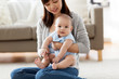 © Syda Productions - family and motherhood concept - happy smiling young asian mother with little baby at home
