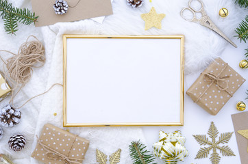 Christmas golden frame mock up made of christmas decoration, balls, cones, golden star, gift box and fir tree. Flat lay, top view. Trendy greeting card, hand craft gifts