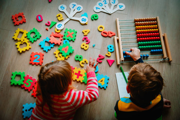 Wall Mural - little boy and girl learn to calculate numbers