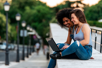 Wall Mural - Beautiful women using a laptop in the Street.