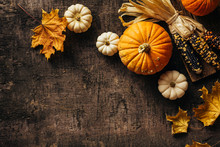 Pumpkins And Corn And Autumn Leaves On Old Shabby Background. Autumn Background With Copy Space.