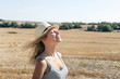 © ADDICTIVE STOCK - Young woman smiling and feeling the breeze in a field in summer