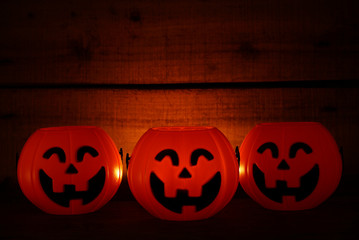 Three pumpkins smile on wood background for halloween theme