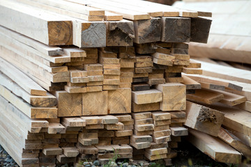 Poster - Close-up of piled stack of natural brown uneven rough wooden boards lit by bright sun. Industrial timber for carpentry, building, repairing and furniture, lumber material for construction.