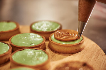 Process of making tart with salted caramel french dessert. Food industry, mass or volume production.