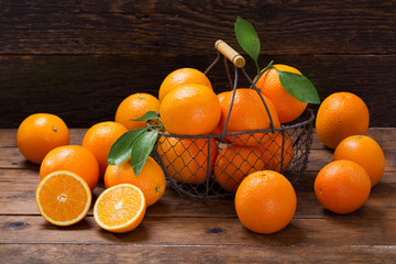 Wall Mural - fresh orange fruits in a basket on wooden table