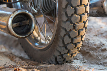 Motorcycle wheel on a sandy road, close-up