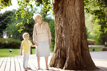 Beautiful granny and her little grandchild together walking