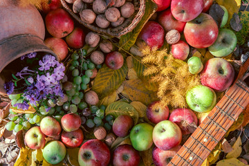 Healthy food background autum leaves, grapes, apples, walnut, flowers, earthenware jug for wine, a set of vitamins, health, fruits, harvest. Thanksgiving day concept. Top view with copy space