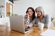 © BONNINSTUDIO/Stocksy - Mother and her daughter using laptop at home.